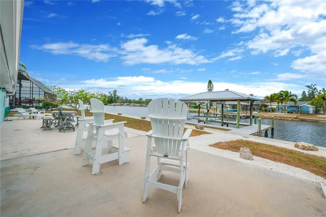 a view of swimming pool with lawn chairs and large tree