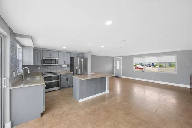 a view of a big room with windows and kitchen view