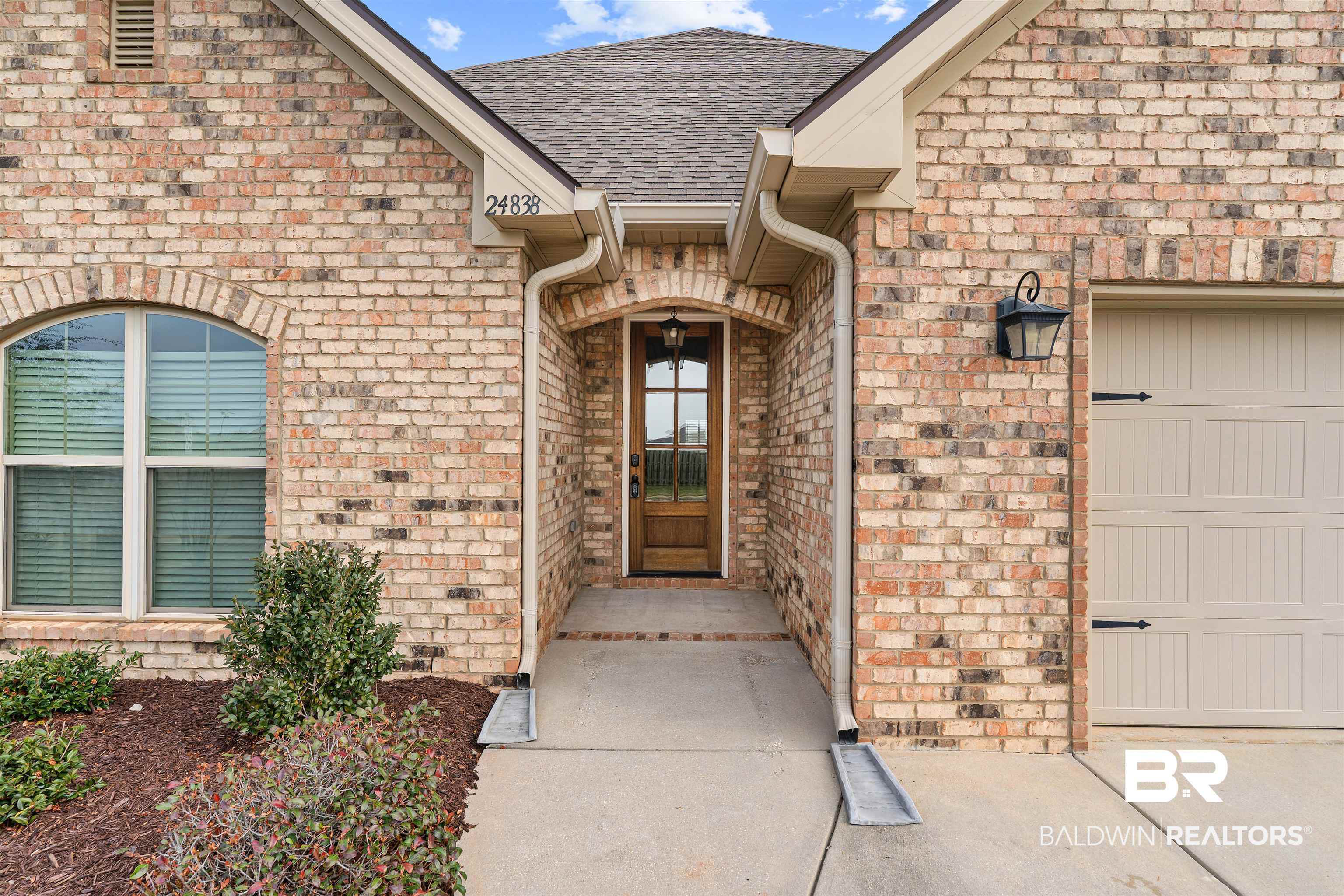 24838 Slater Mill Road Daphne, AL 36526 - Photo 2 of 46 View of exterior entry with brick siding, a garage, and roof with shingles