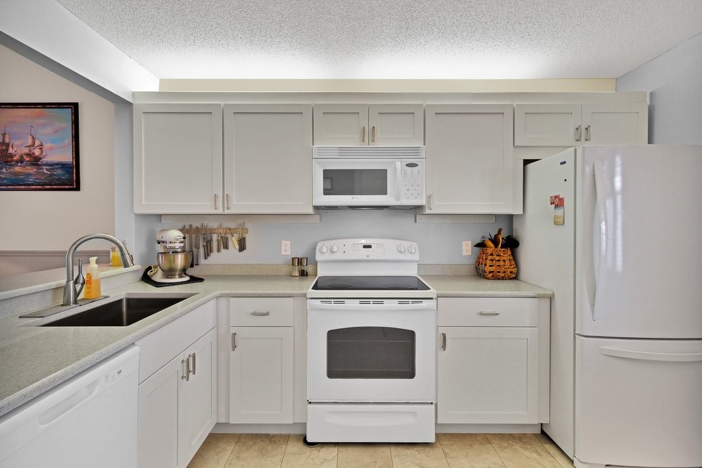 9637 Riverside Drive, Unit 3 Sebastian, FL 32958 - Photo 9 of 36 a kitchen with cabinets stainless steel appliances and a sink