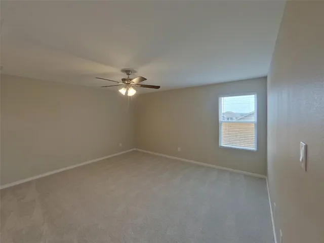 an empty room with a window and a fan