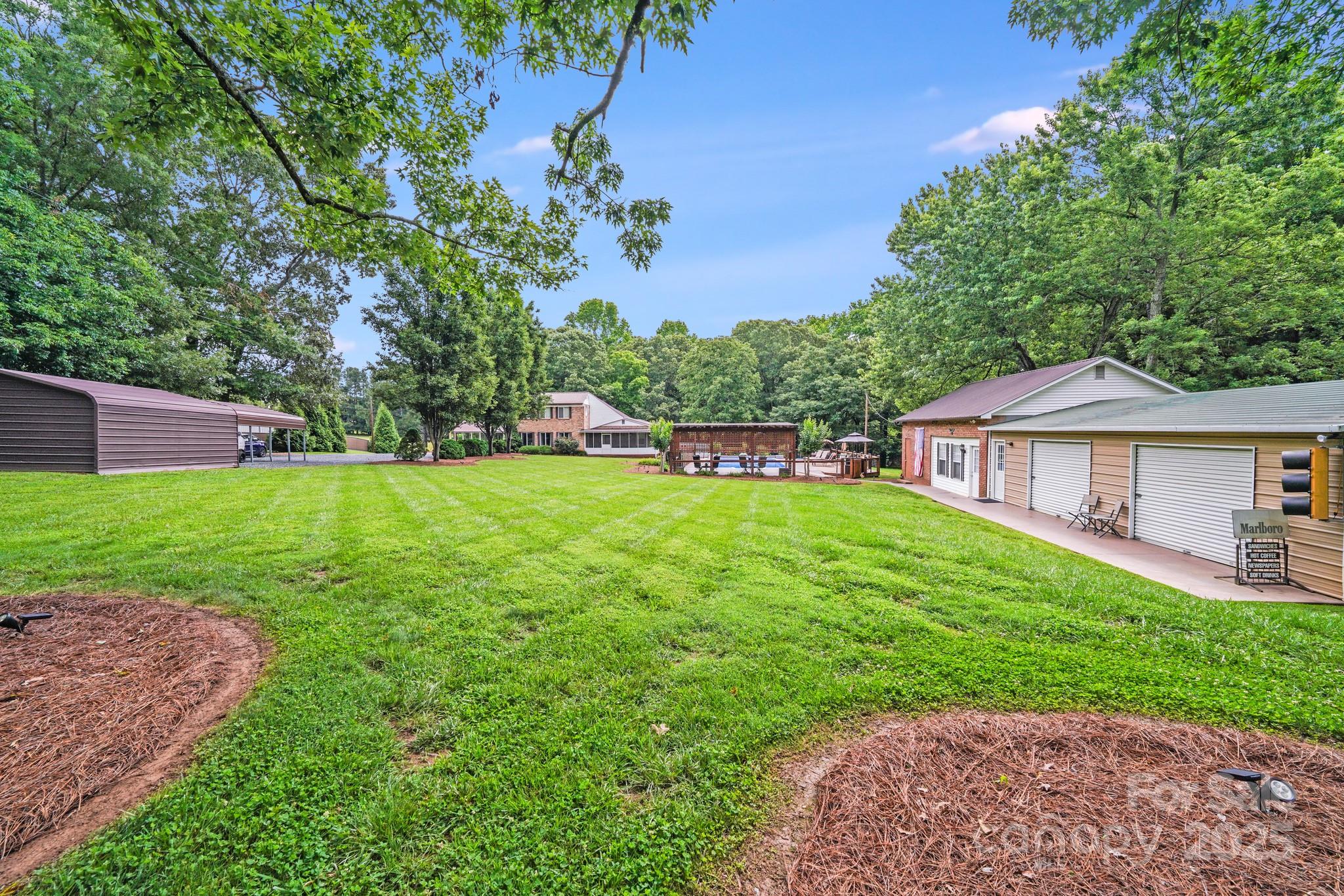 211 Drive Inn Road Locust, NC 28097 - Photo 11 of 48 a view of a house with a big yard potted plants and large tree
