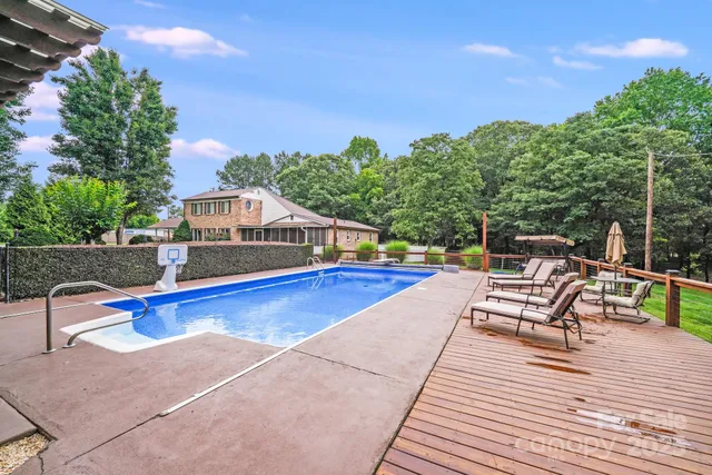 a swimming pool with lawn chairs