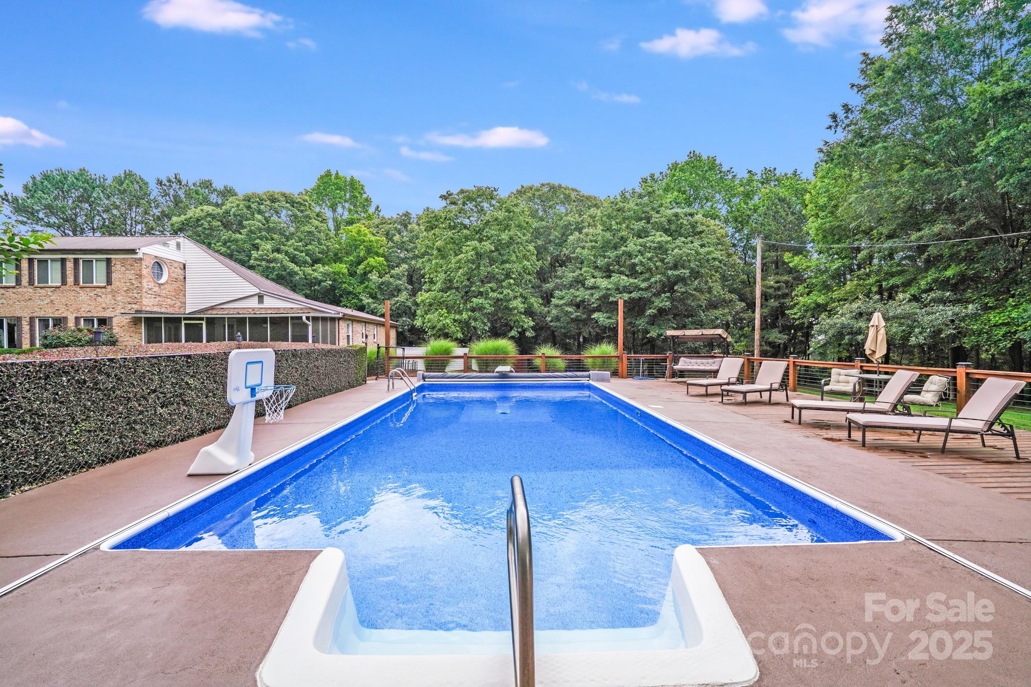 211 Drive Inn Road Locust, NC 28097 - Photo 15 of 48 a swimming pool with lawn chairs
