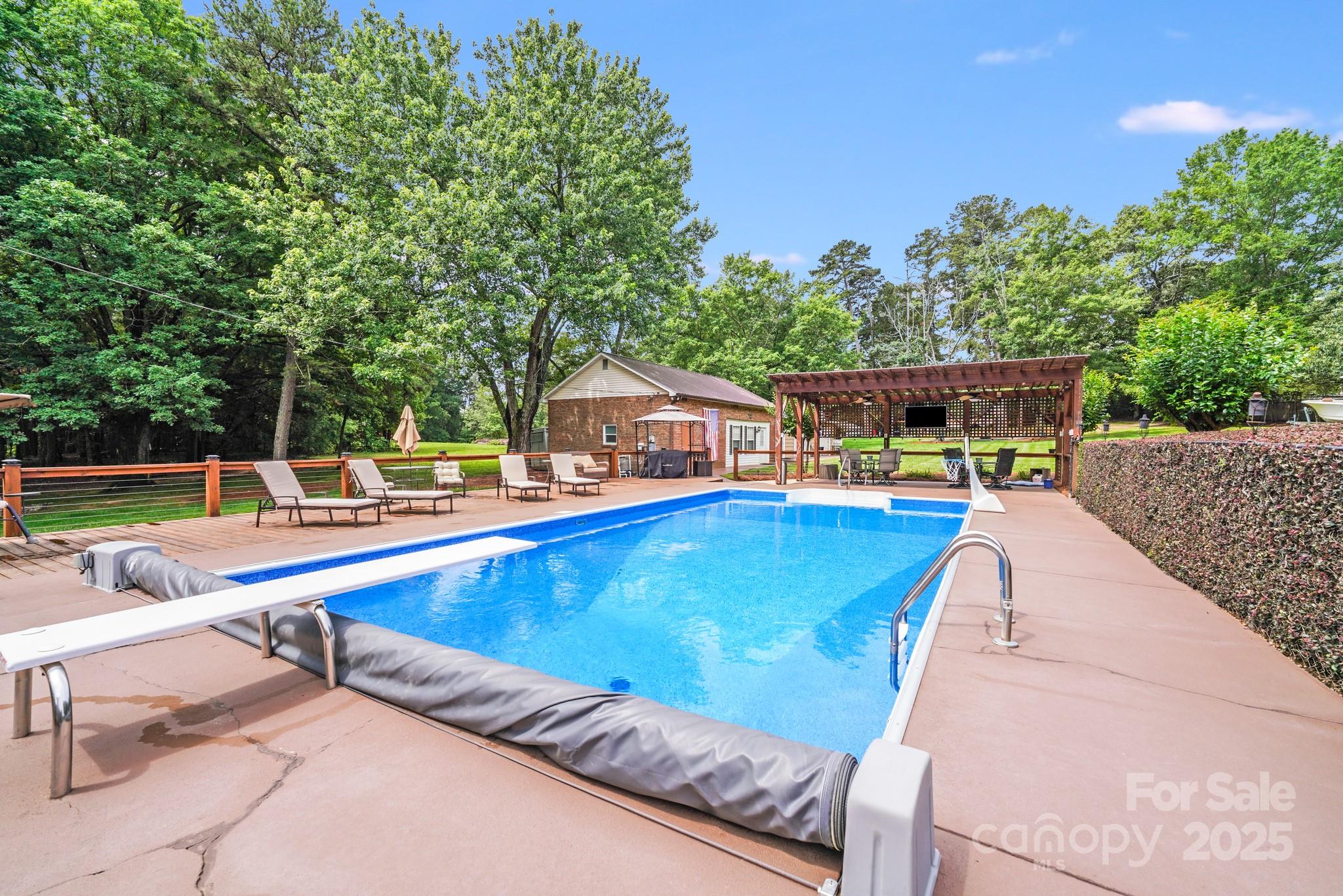 211 Drive Inn Road Locust, NC 28097 - Photo 16 of 48 a view of a swimming pool with a lounge chairs