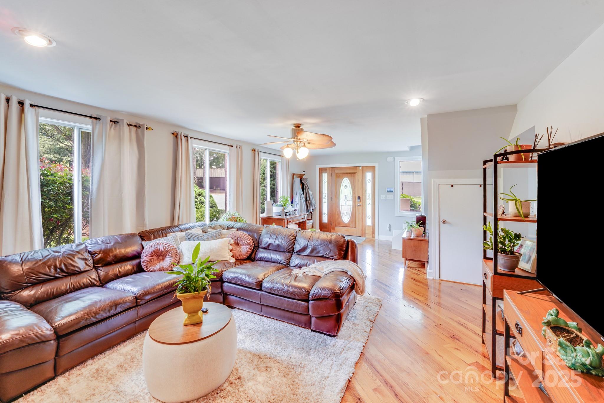 211 Drive Inn Road Locust, NC 28097 - Photo 30 of 48 a living room with furniture potted plant and a flat screen tv