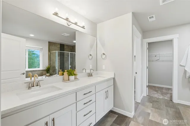 a bathroom with double sink and a mirror