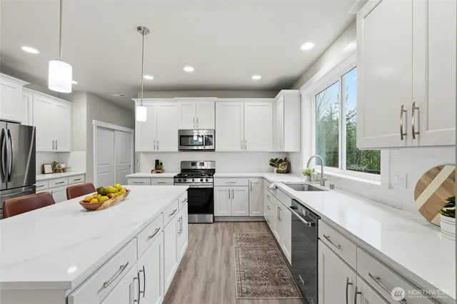 a kitchen with stainless steel appliances a stove sink microwave and cabinets