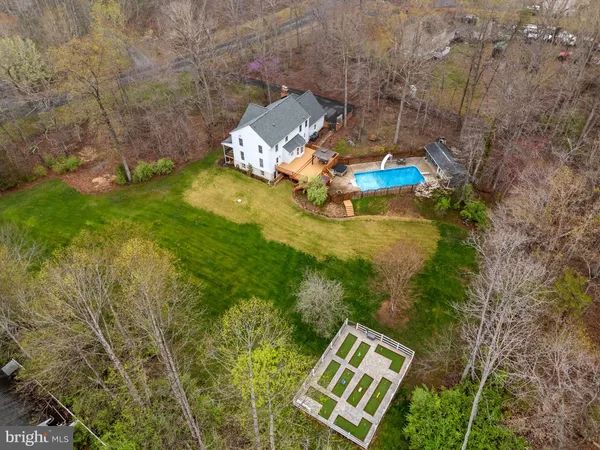 a view of a white house with a big yard and large tree