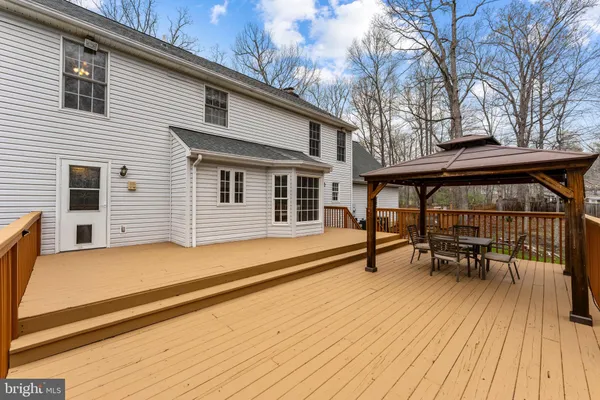 a balcony with wooden floor table and chairs