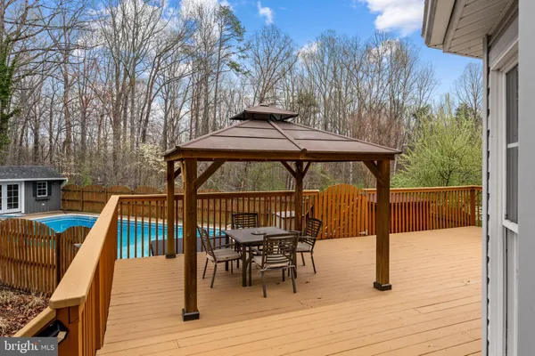 a view of a patio with couches and table potted plants and large tree