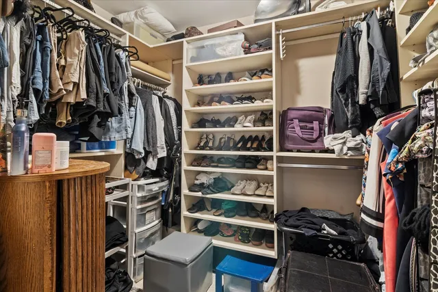 a view of walk in closet with clothes and shoes