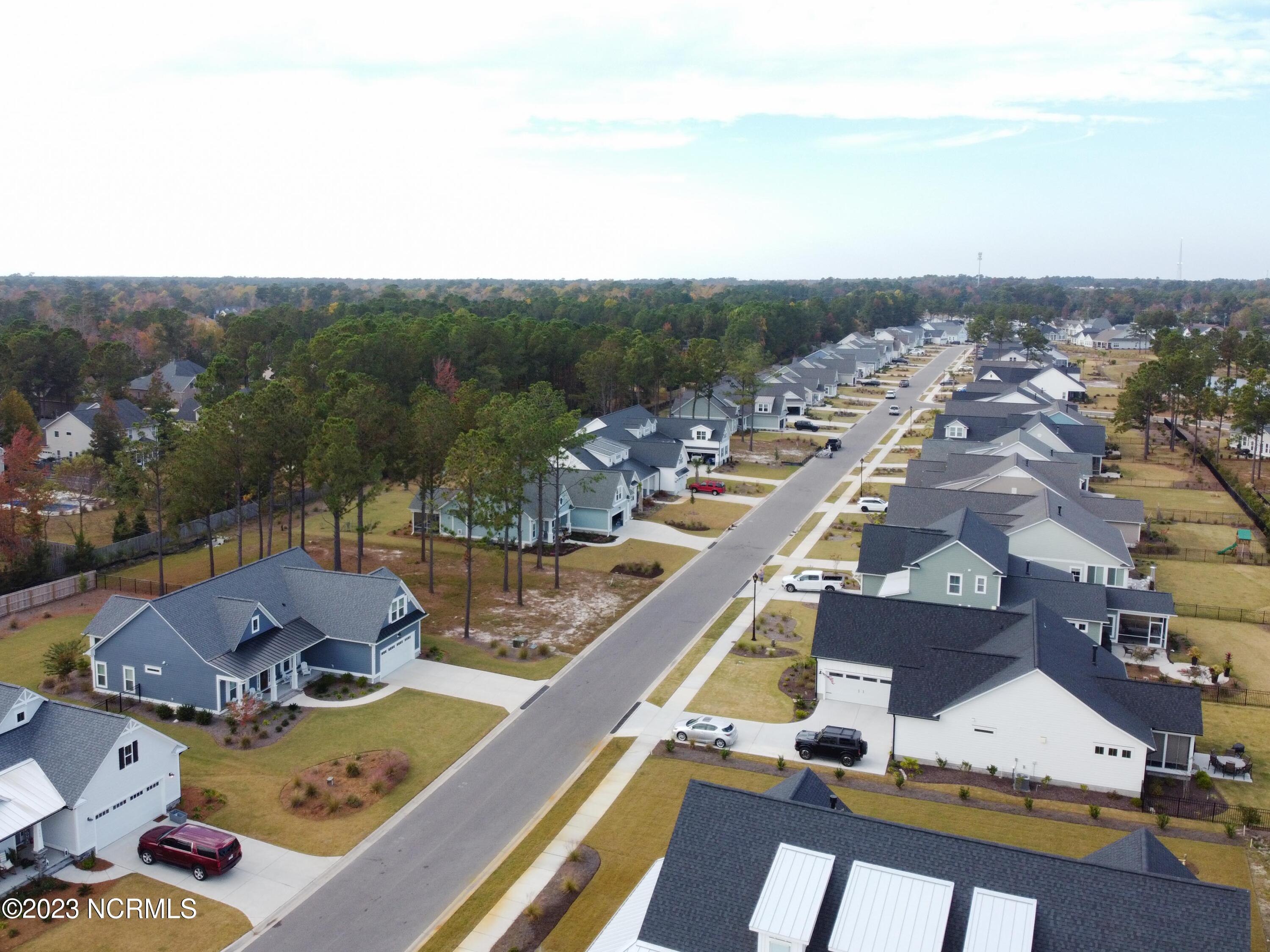 326 Jackline Drive Hampstead, NC 28443 - Photo 3 of 11 View of neighboring homes in the community. Lot is on the left with trees.