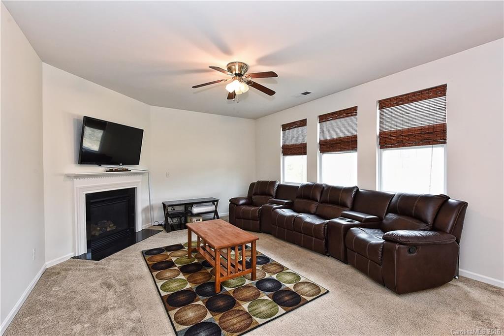 1025 Skillbeck Road Indian Trail, NC 28079 - Photo 11 of 24 a living room with furniture a fireplace and a flat screen tv