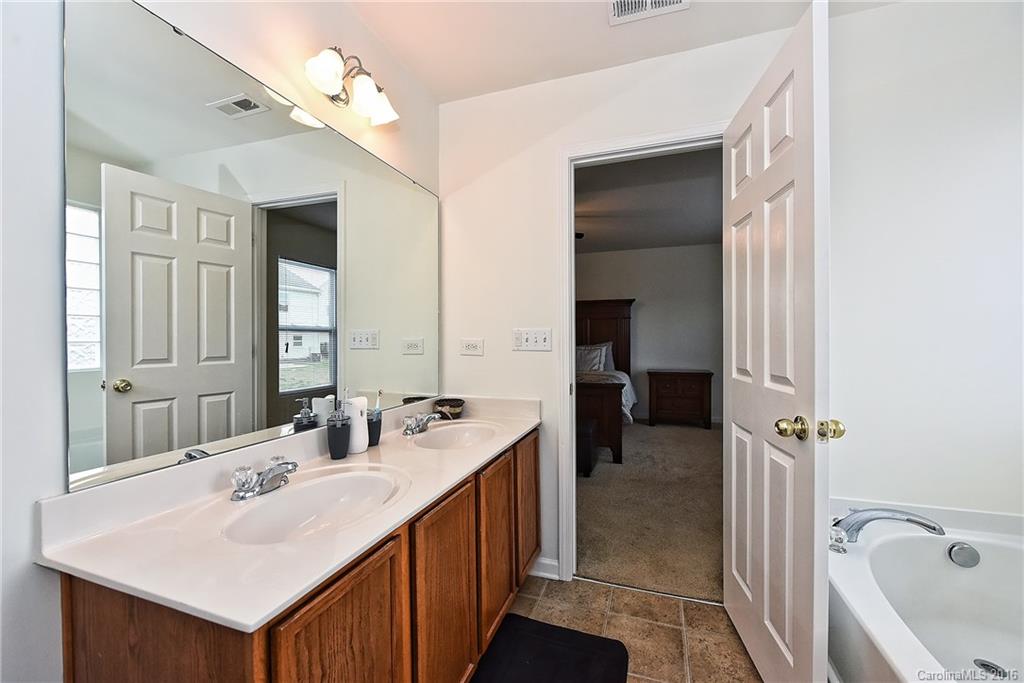 1025 Skillbeck Road Indian Trail, NC 28079 - Photo 17 of 24 a en suite bathroom with a double vanity sink a mirror and a shower