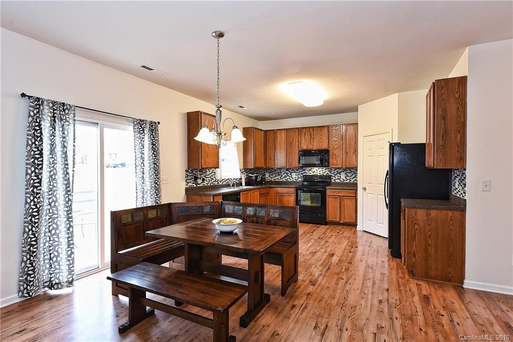 1025 Skillbeck Road Indian Trail, NC 28079 - Photo 7 of 24 a kitchen with stainless steel appliances granite countertop a refrigerator a stove and a wooden floors