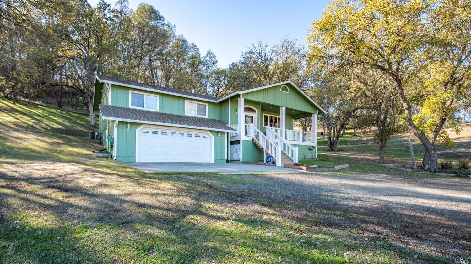10157 Bell Avenue Lower Lake, CA 95457 - Photo 1 of 55 a view of a house with a yard and large trees