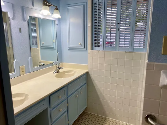 a bathroom with a double vanity sink and a mirror