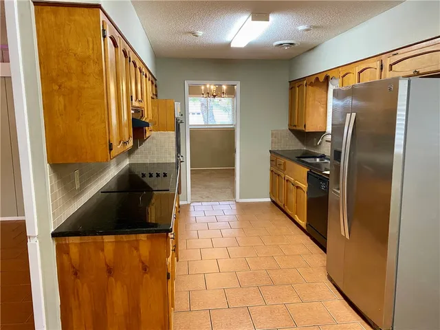 a kitchen with stainless steel appliances granite countertop a refrigerator and a sink