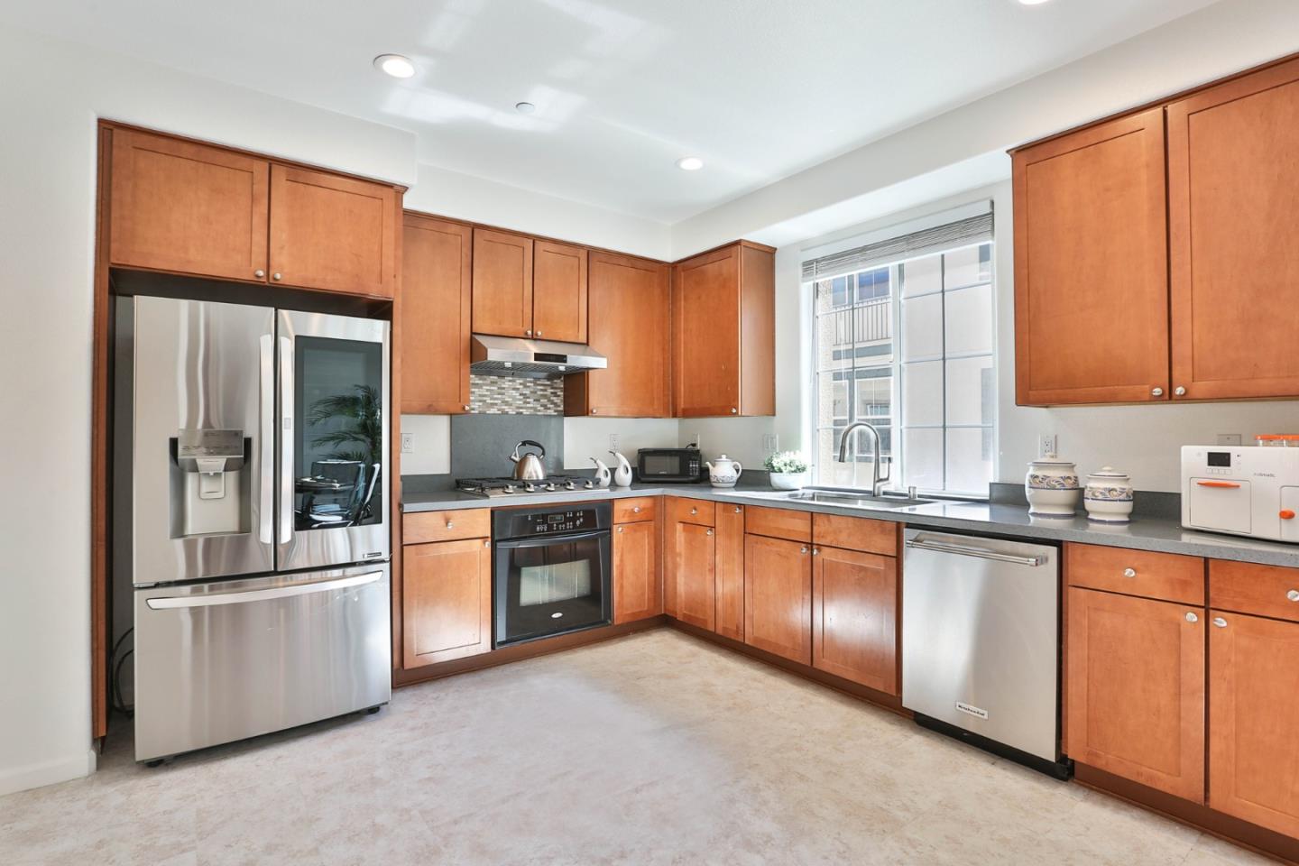 1105 Luz Del Sol Tr Loop Milpitas, CA 95035 - Photo 11 of 34 a large kitchen with stainless steel appliances granite countertop a refrigerator a sink dishwasher a stove and white cabinets with wooden floor