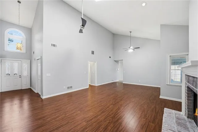 an empty room with wooden floor and a fireplace