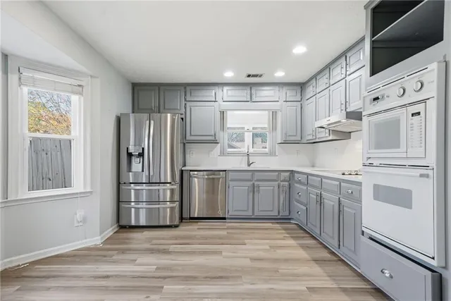 a kitchen with stainless steel appliances granite countertop a refrigerator and a stove top oven