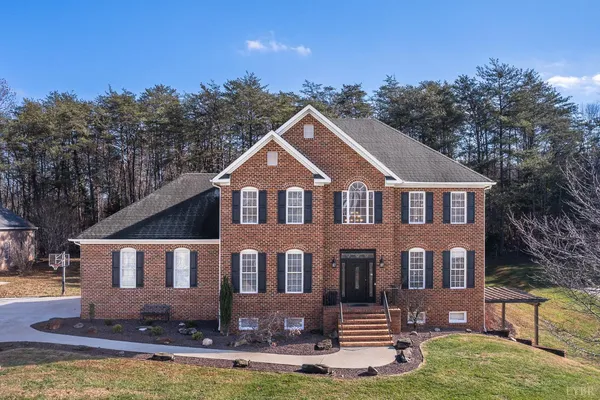 a front view of a house with yard and green space