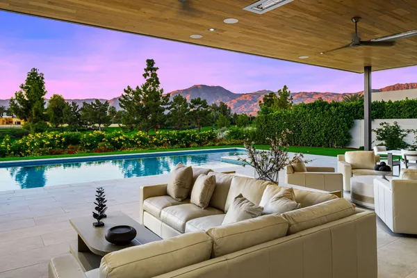 a swimming pool with outdoor seating and yard