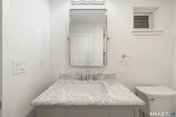 a bathroom with a granite countertop sink and a mirror