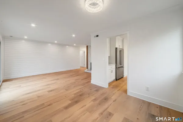 a view of a big room with wooden floor and windows