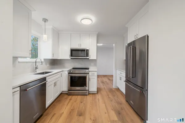 a kitchen with stainless steel appliances a refrigerator sink and microwave