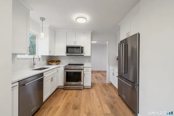 a kitchen with stainless steel appliances a refrigerator sink and microwave