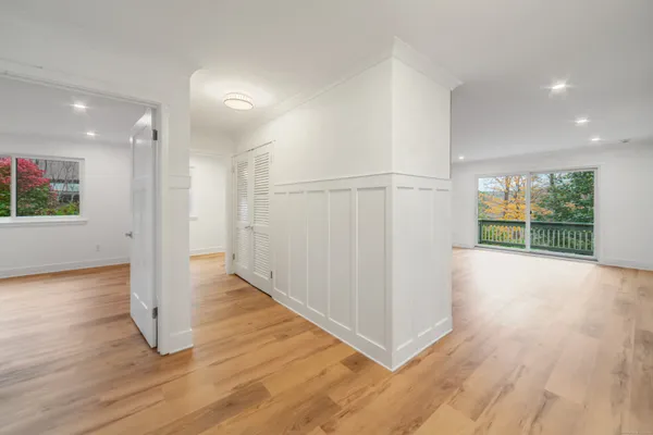 an empty room with wooden floor and windows