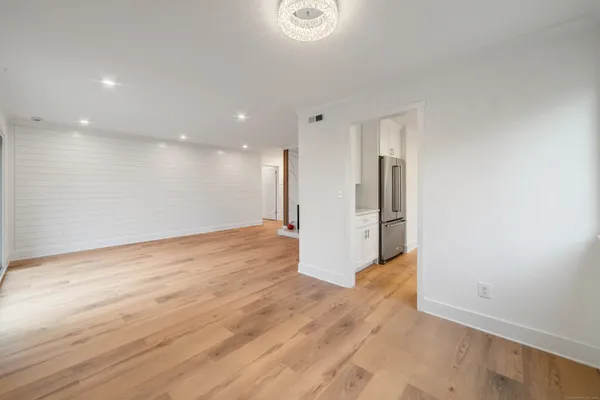 a view of a big room with wooden floor and windows