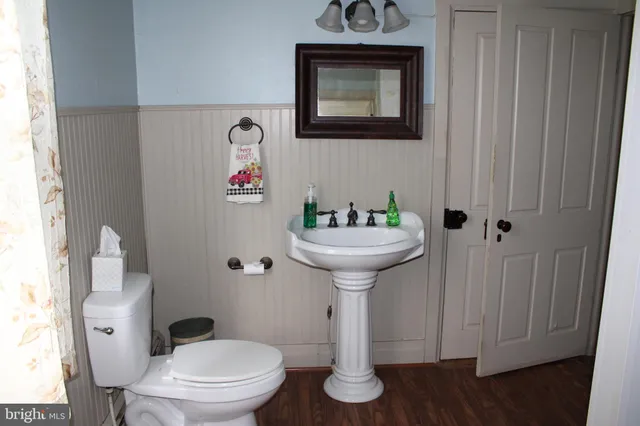 a bathroom with a toilet sink and mirror