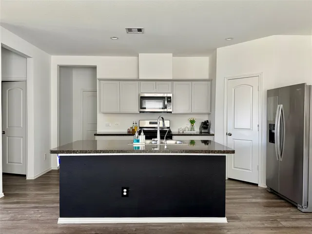 a kitchen with kitchen island a sink a refrigerator and cabinets