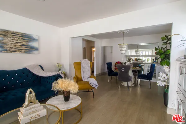 a living room with furniture two window and wooden floor