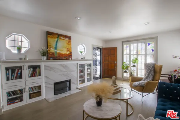 a dining room with furniture potted plants and wooden floor