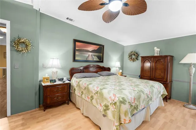 a bedroom with bed and wooden floor