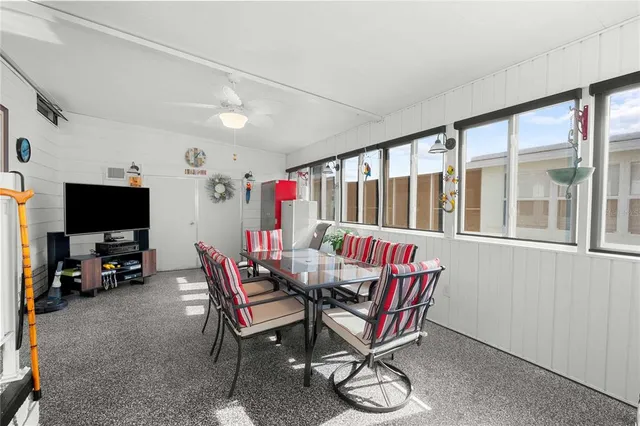 a view of a dining room with furniture a chandelier and a flat screen tv