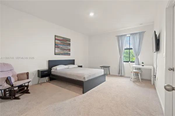 a bedroom with a bed and painting on the wall