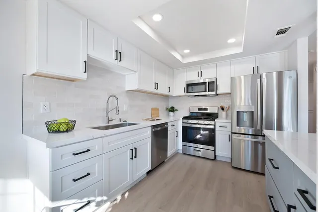 a kitchen with cabinets stainless steel appliances and a counter space