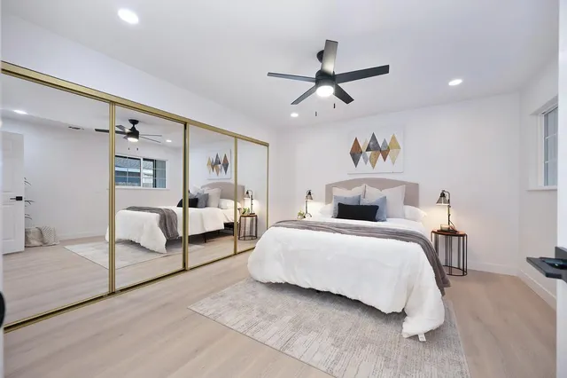 a bedroom with a large bed and a chandelier