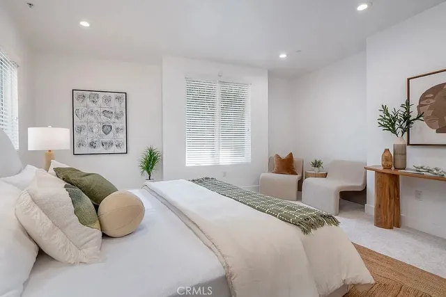 a bedroom with bed and a potted plant