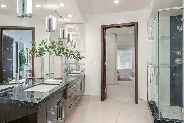 a bathroom with a granite countertop sink a mirror and a shower