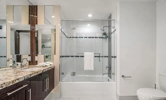 a bathroom with a granite countertop sink mirror toilet and bathtub