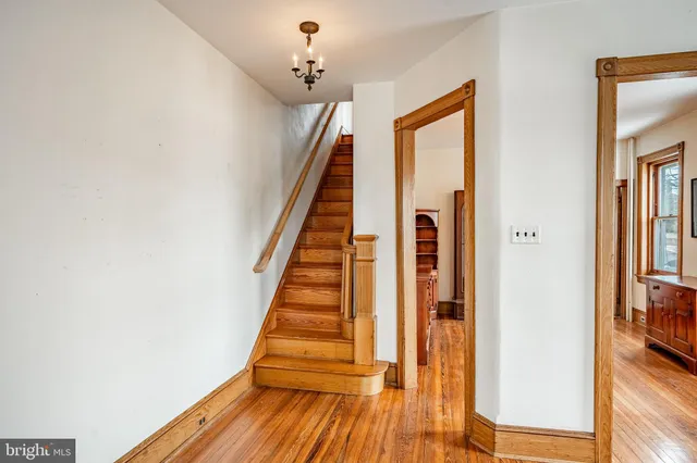 a view of a hallway with wooden floor and staircase