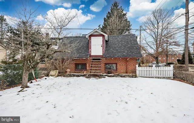 a front view of a house with a yard covered with snow