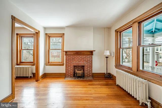 a view of empty room with wooden floor and fireplace