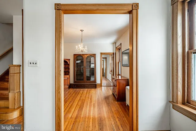 a view of a hallway with wooden floor and furniture